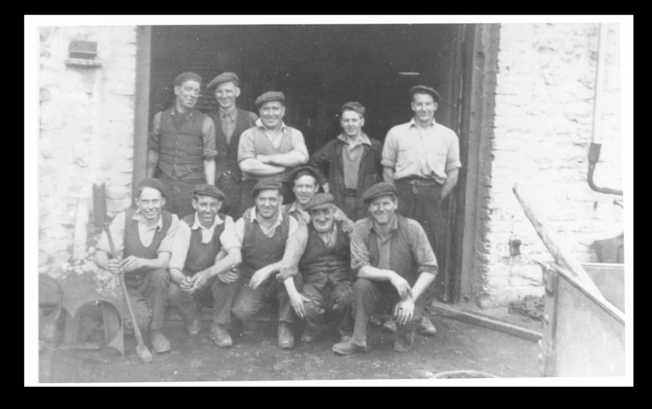 Group photograph of 11 men outside the blacksmiths shop at Big Pit