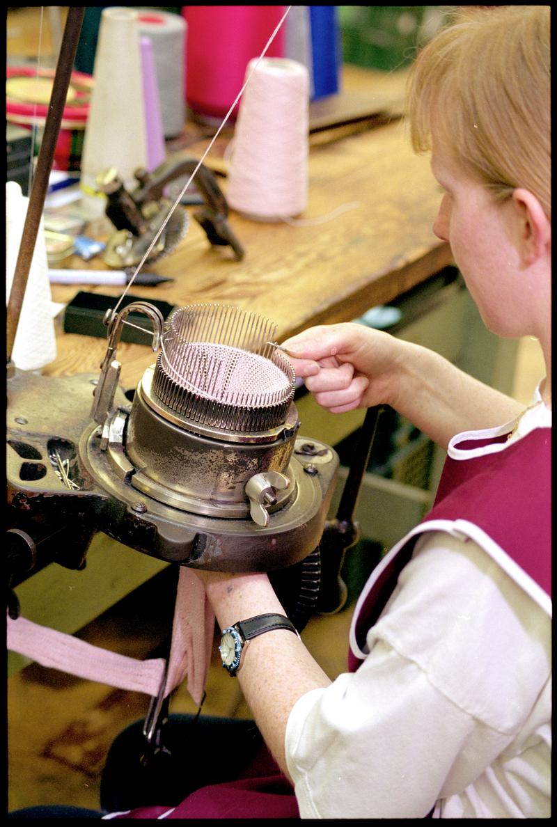 Andrea Rockman raising needles around a sock knitting machine to turn the heel.