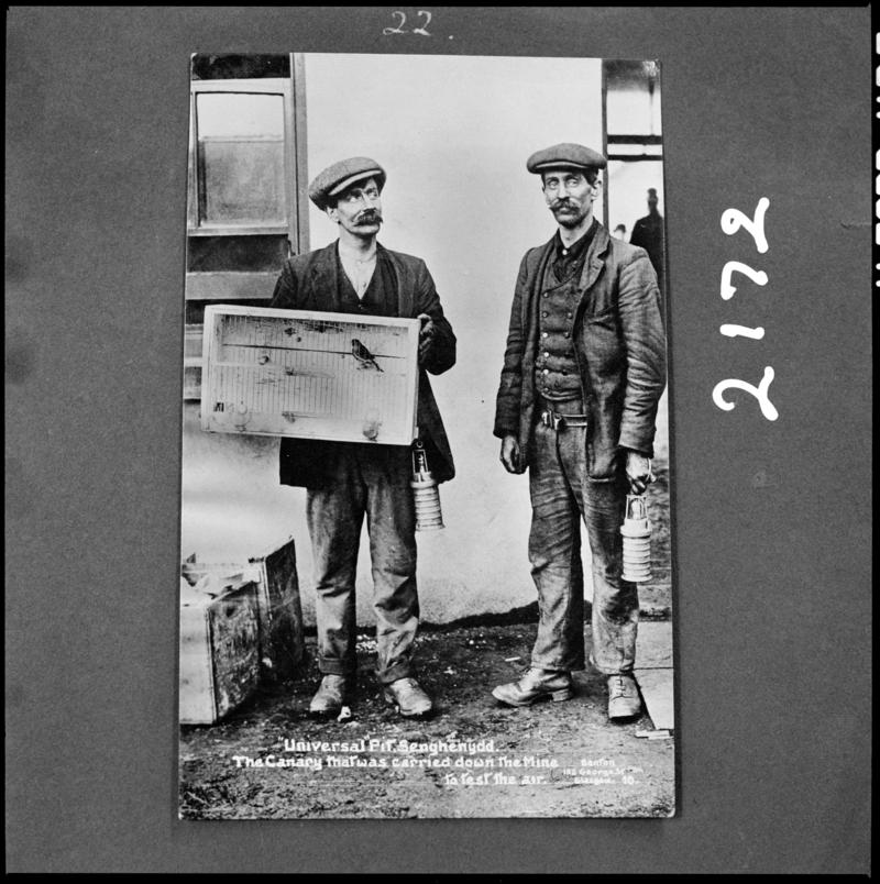 Black and white film negative of a photograph showing two men, one of whom is carrying a canary in a cage, Universal Colliery, 1913.  &#039;Sen 1913&#039; is transcribed from original negative bag.