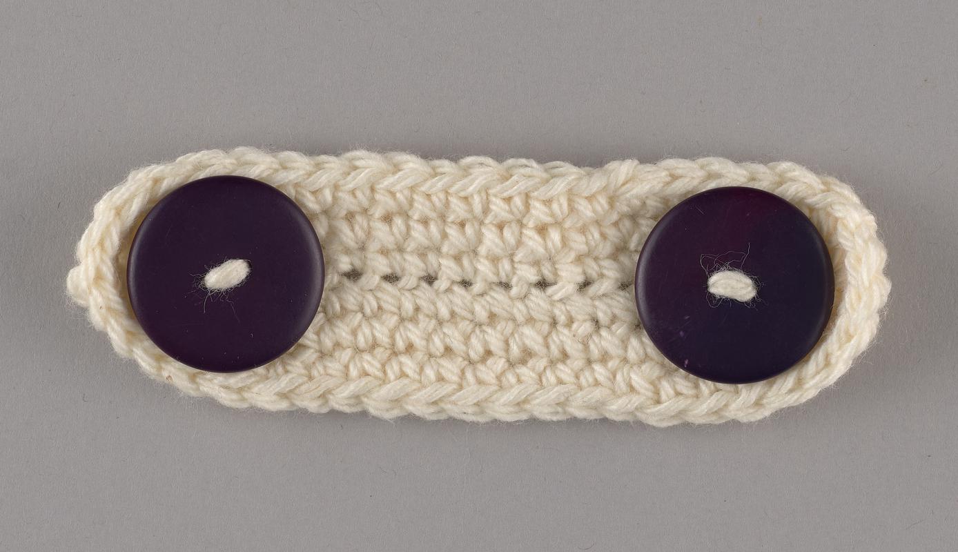Hand-knitted ear protector/mask extender. White with purple buttons.