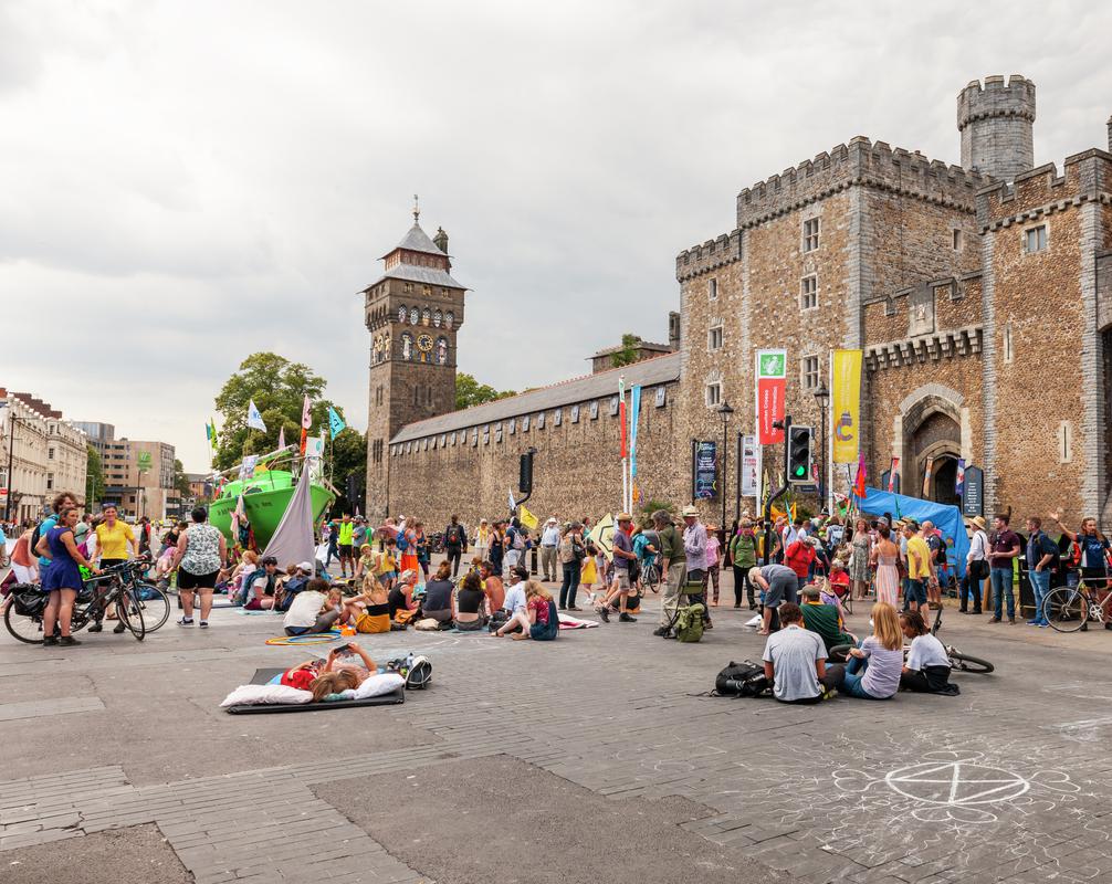 Extinction Rebellion Protest in Cardiff, blocking the road outside Cardiff Castle with a green yacht and Protest Slogans.