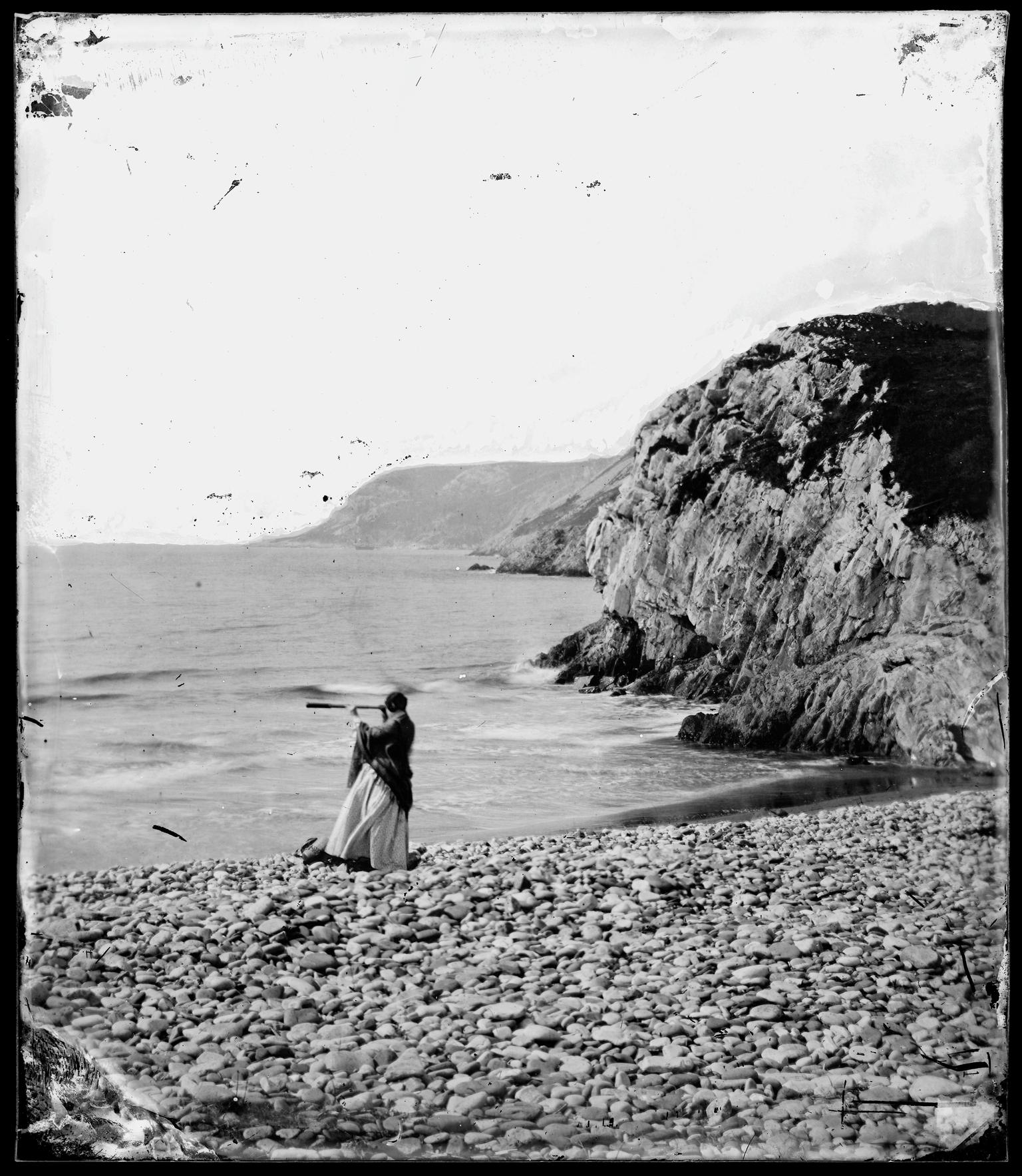 Thereza at Caswell Bay with telescope, glass neg