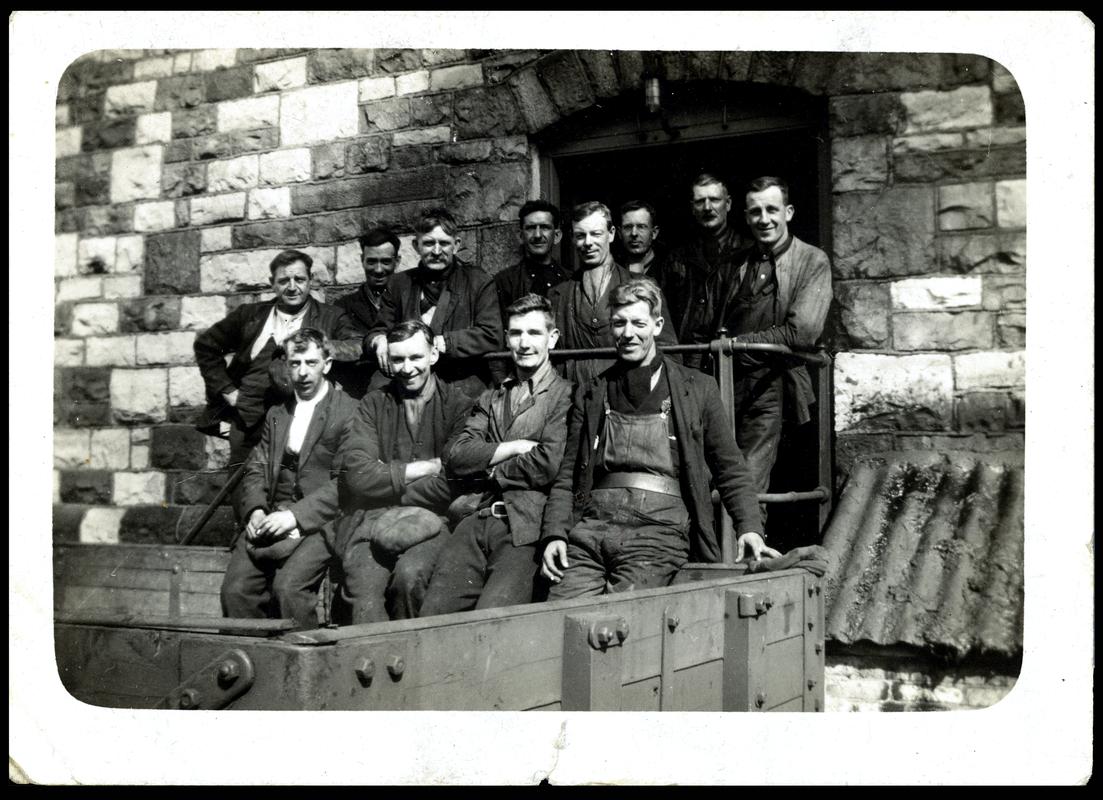 Workmen (blacksmiths) sitting in dram outside winding house, Big Pit
