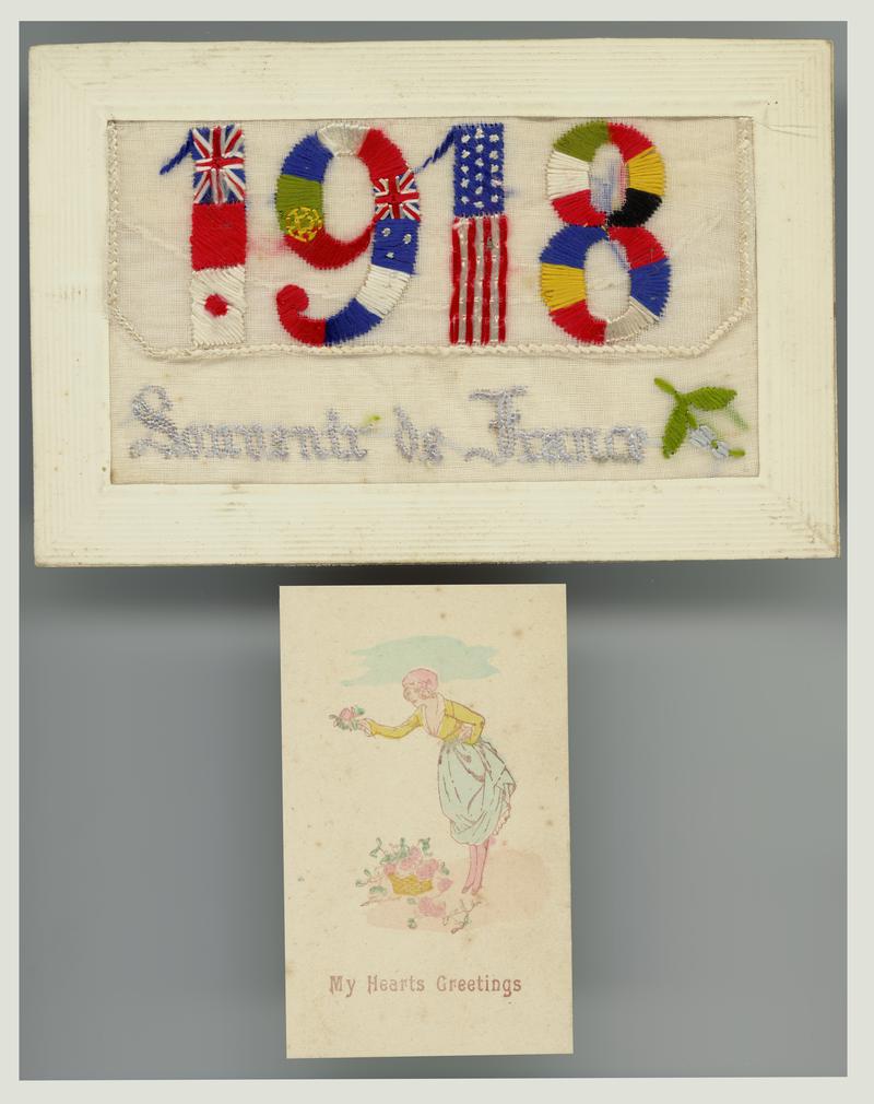 Embroidered postcard featuring the date 1918. With a small &#039;My Hearts Greetings&#039; card inserted into a pocket on the front. Handwritten message on back.