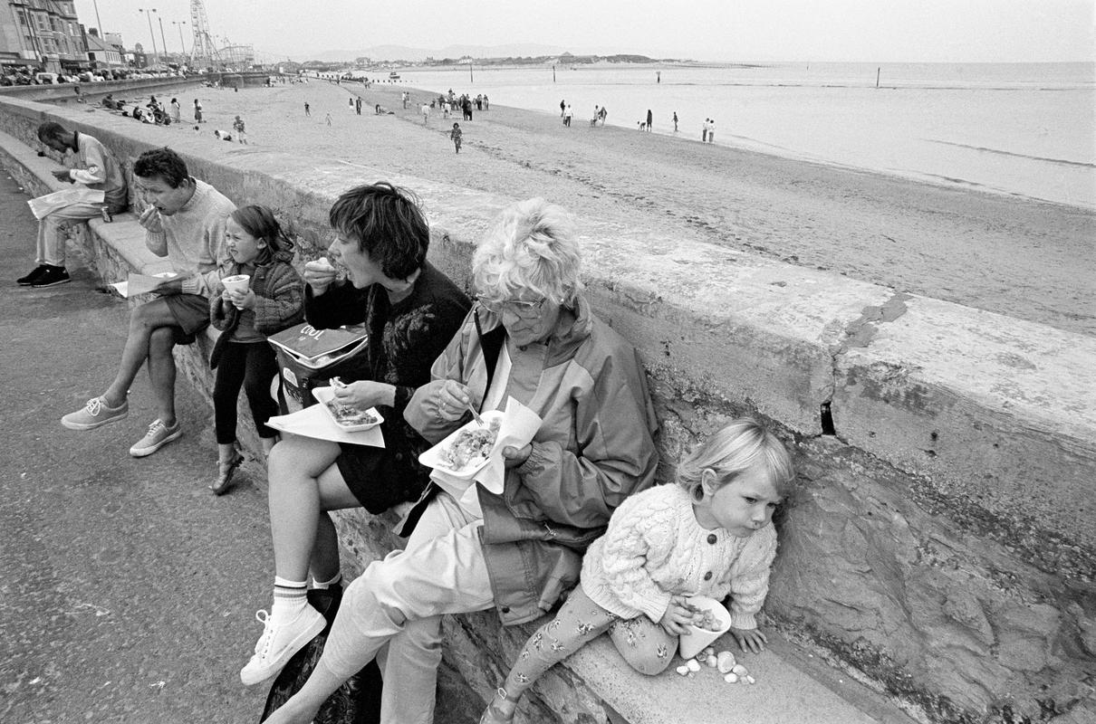 GB. WALES. Rhyl. Family eating fast food, mainly fish and chips by the sea while on holiday. 1997.