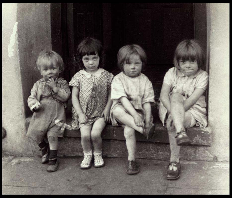 Four small girls sitting on a doorstep, Rhondda