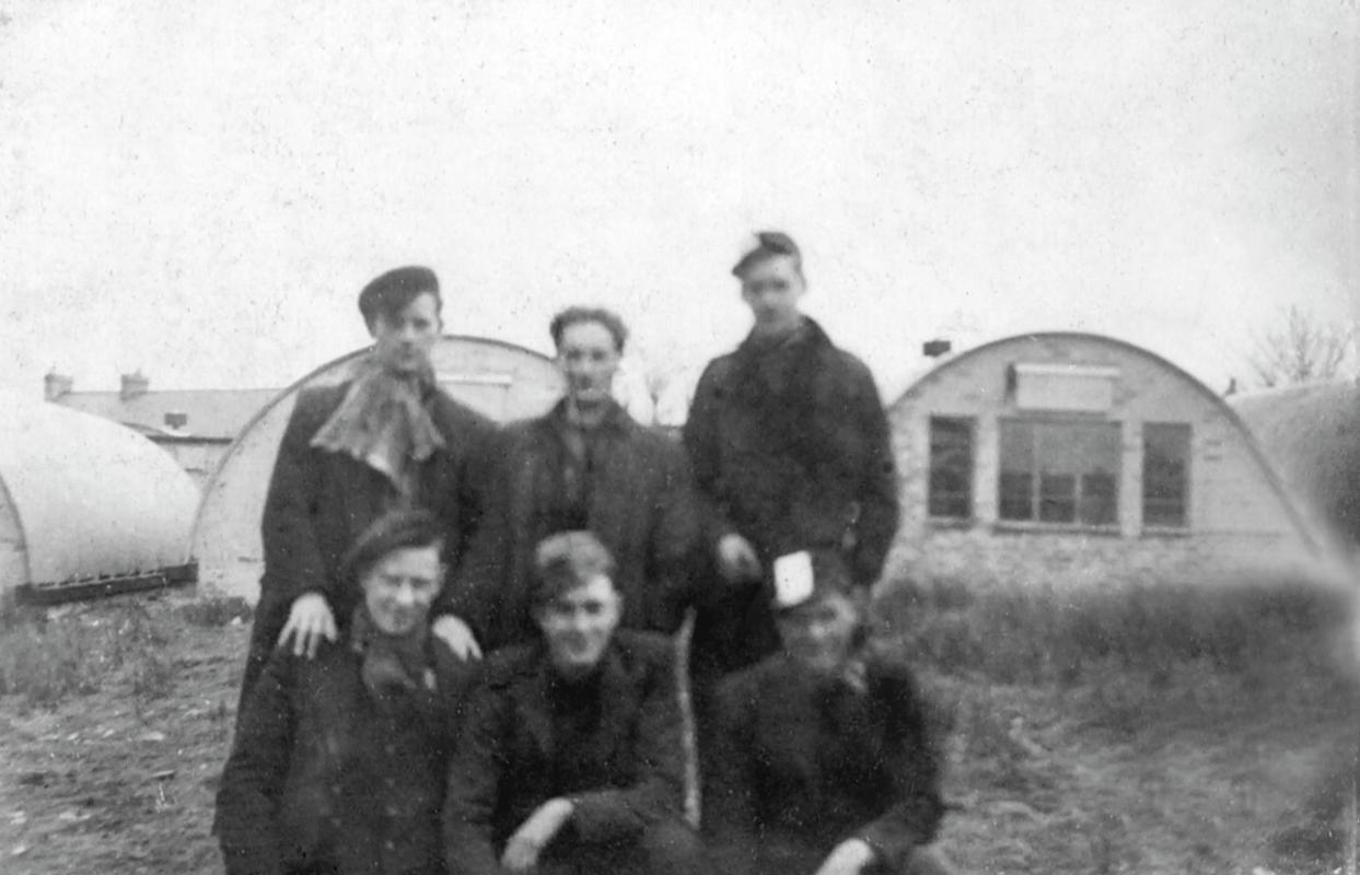 Six Bevin boys with their Nissen Hut living quarters in the background, Hirwaun.