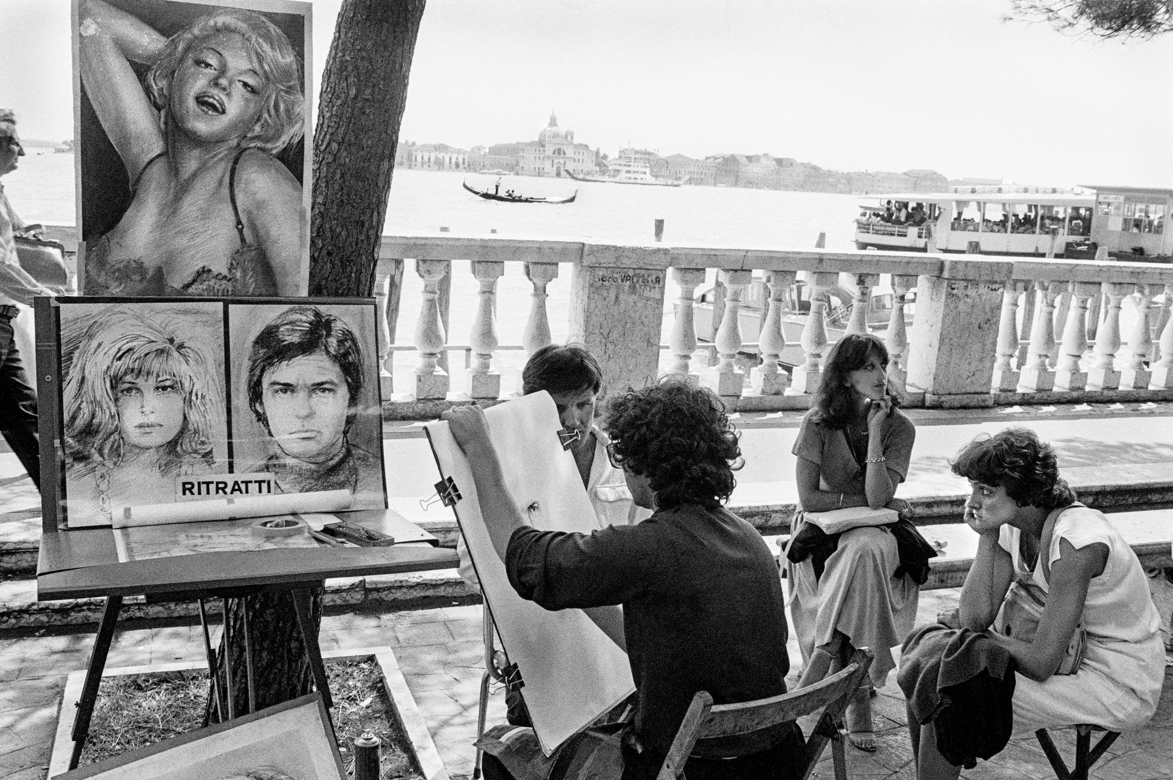 Budding artist draw tourists on the sea front facing San Giorgio Island. Venice. Italy
