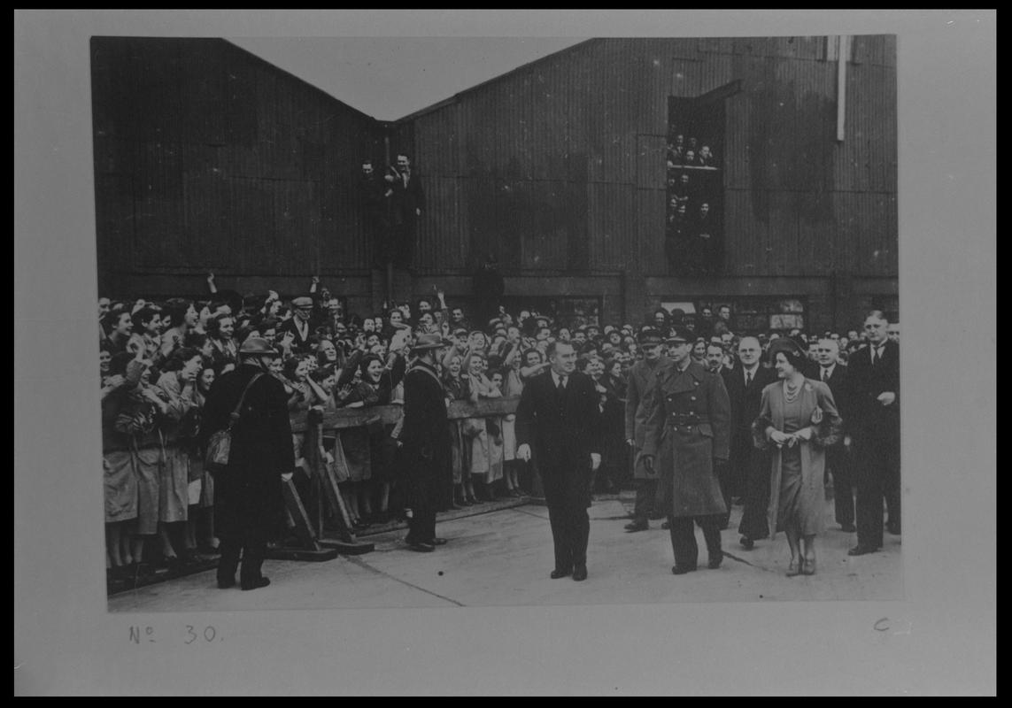 Film negative of a photograph showing visit of King George VI and Queen Elizabeth to Currans, Butetown during World War II.