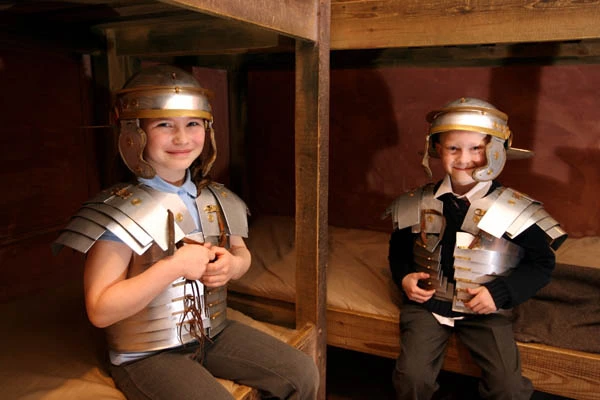 Two boys dressing up in Roman armour