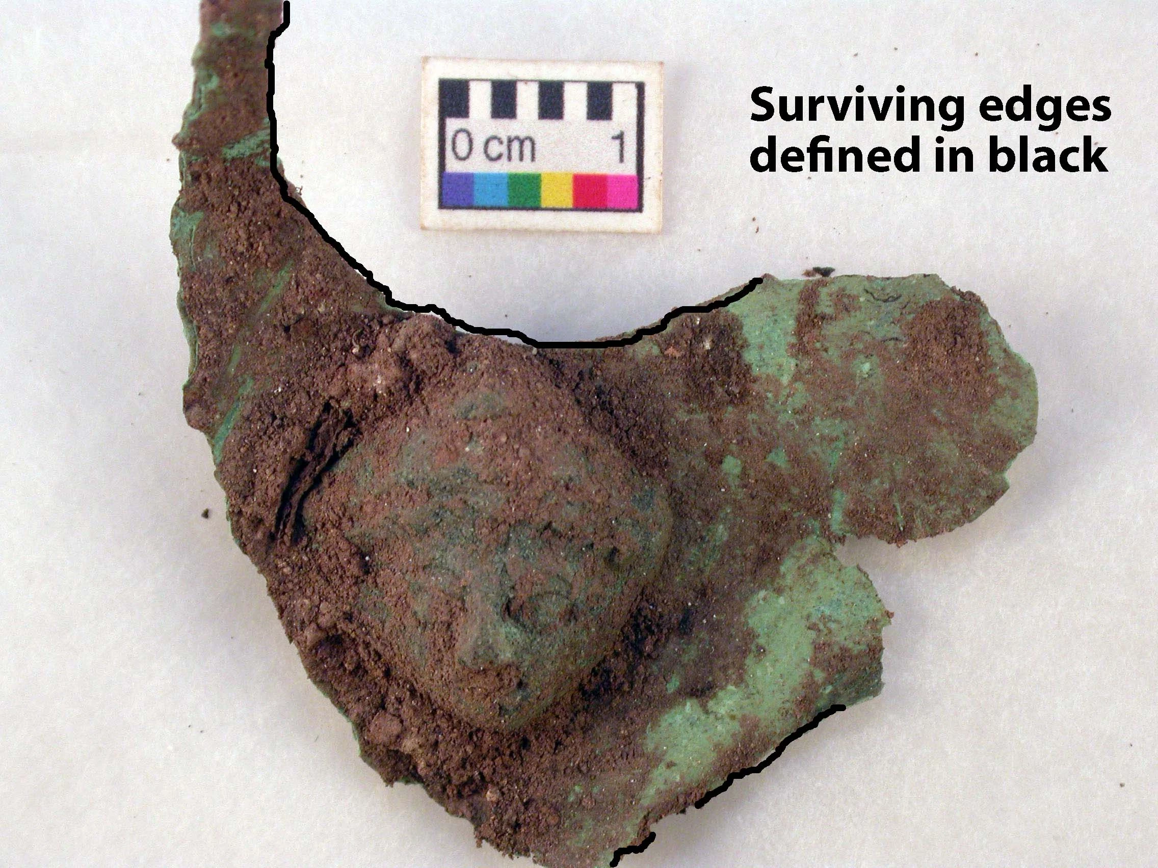 Caerleon Roman Armour. Plaque removed from soil and before cleaning. The condition is good but the edges are fragile. The best preserved edges are defined in black.