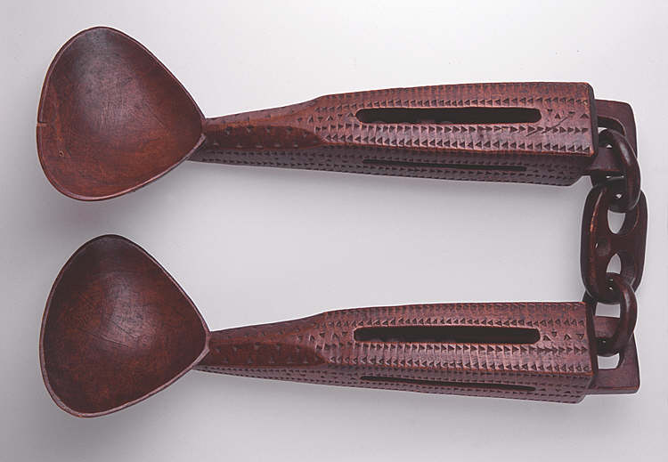 Two heavy lovespoons hanging from two-looped panel