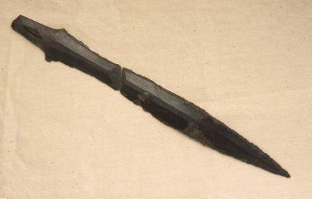 The bronze knife, found in two fragments. The edges of the blade were heavily notched, perhaps suggesting it had been used for some time before burial.