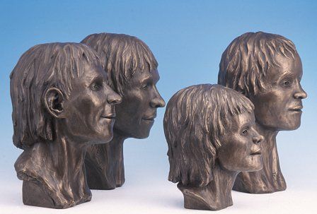 Four of the five faces from Llanbedrgoch, cast in brass.