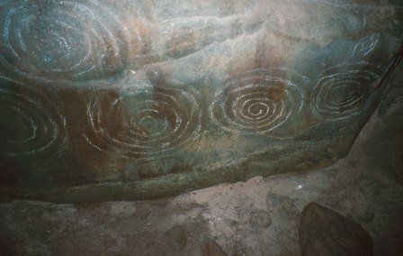 Carved stone inside the chamber of Barclodiad y Gawres (Anglesey). The style of carving in this passage tomb is common to many tombs in Ireland.