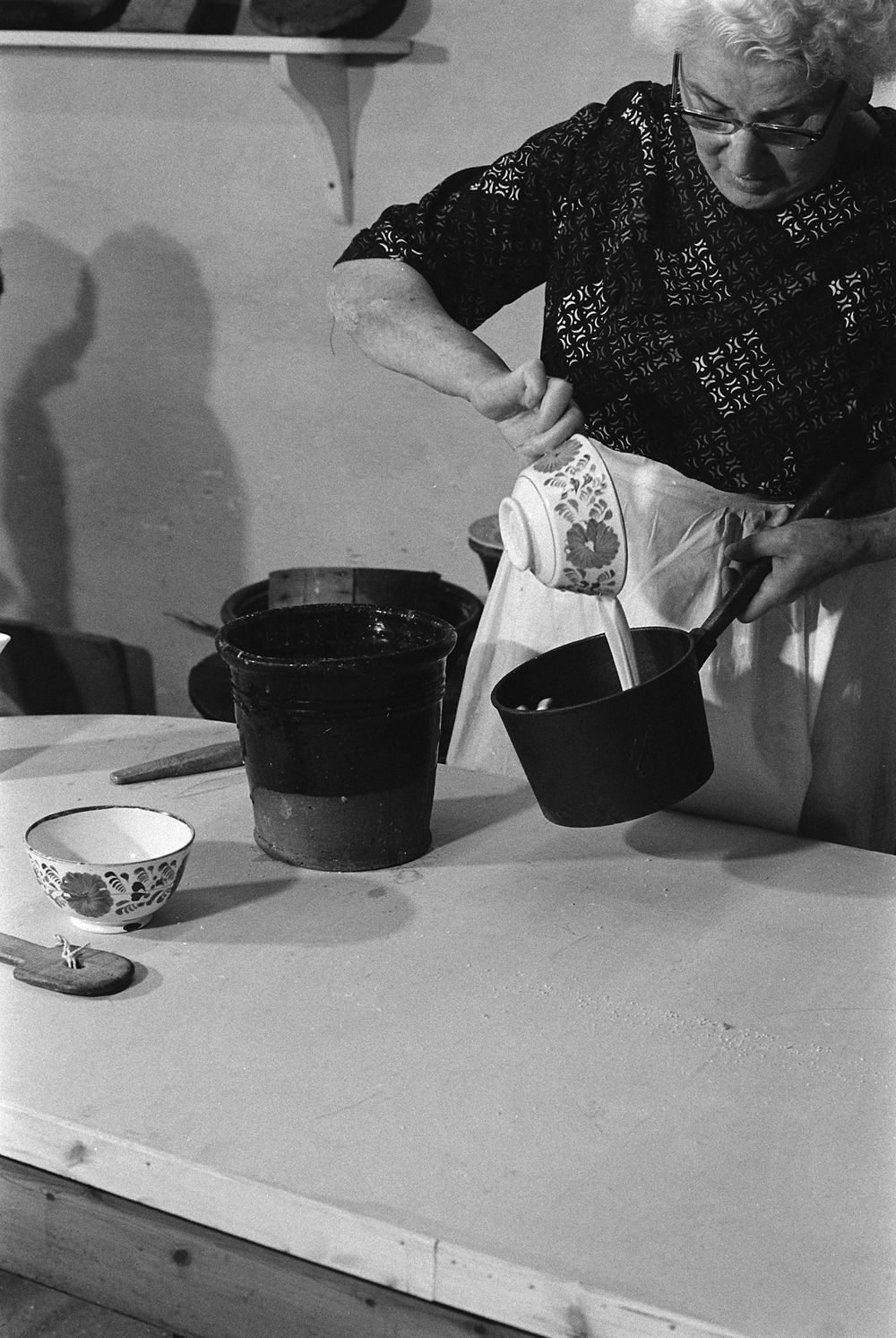Pouring a small quantity into a cast iron saucepan. Mrs Catrin Jones, Bala, Merioneth.