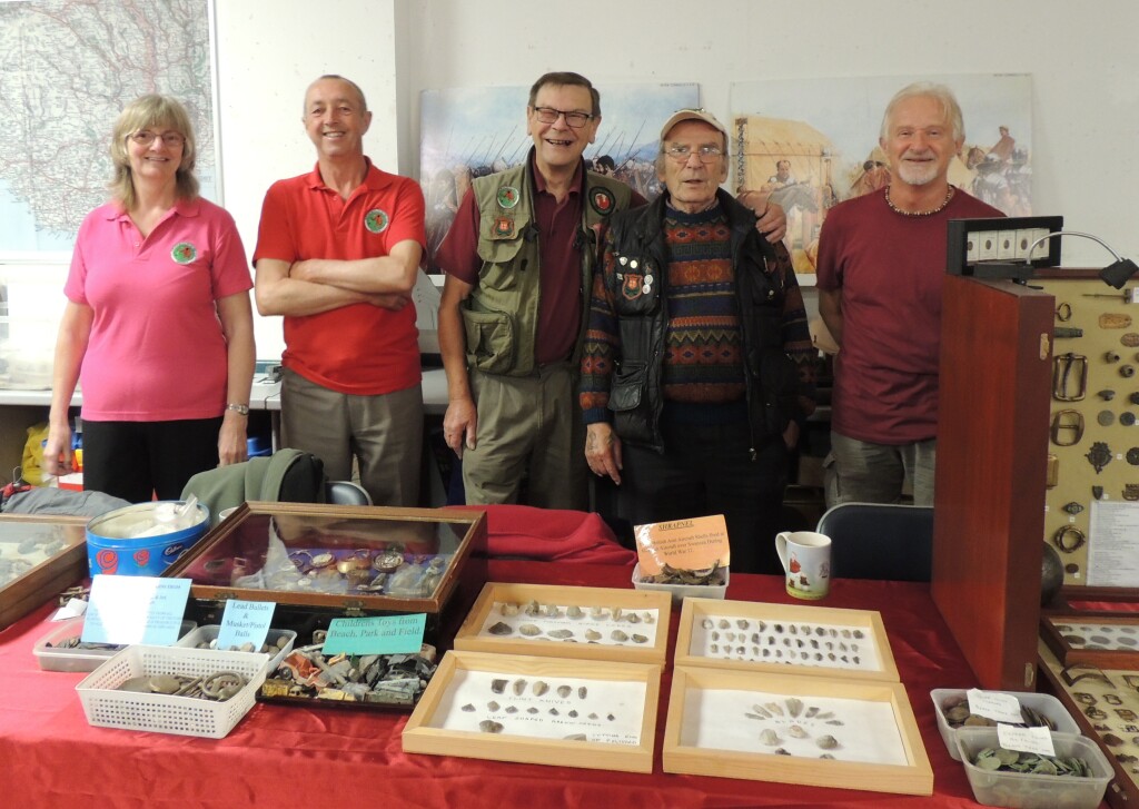 Members of the Heritage Metal Detecting Club, Swansea, are standing behind a display of some of their finds.