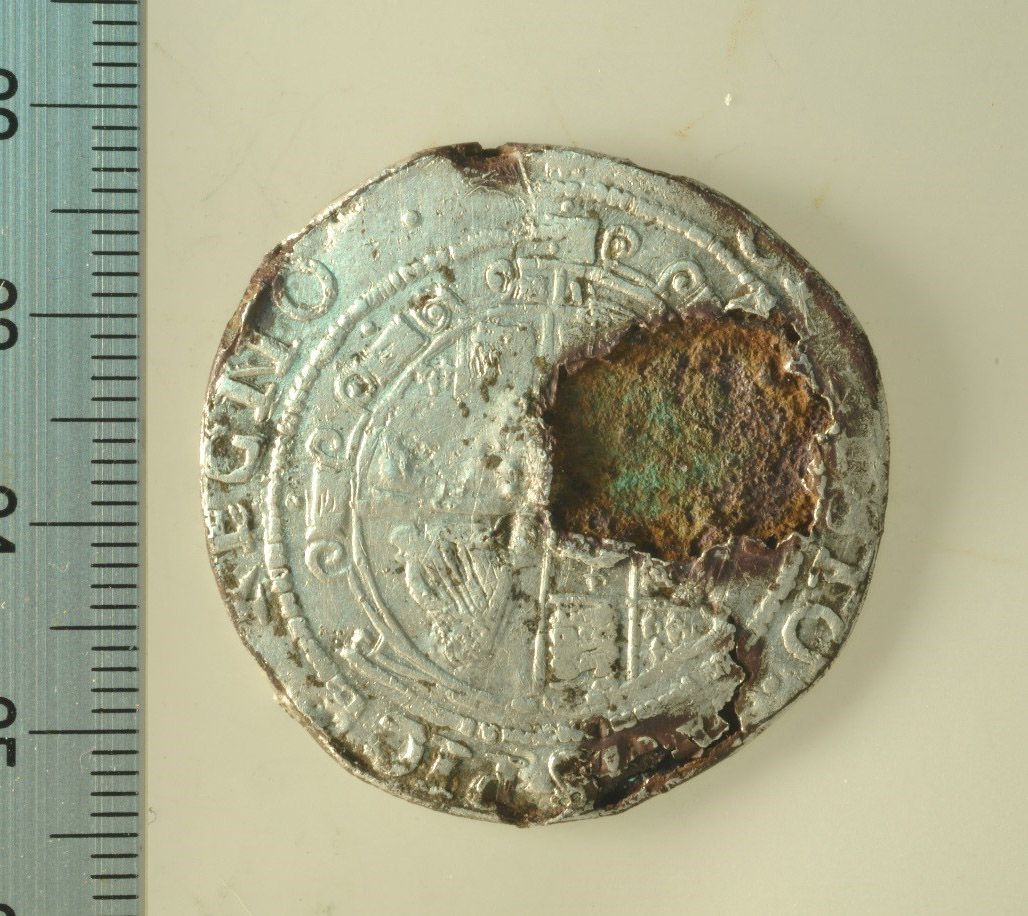 A forged Charles I half-crown. The corroded base metal core can clearly be seen through the thin silver plating.