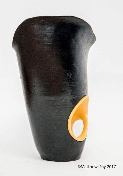 photo showing a black sculptural prosthetic socket with a yellow decoration 