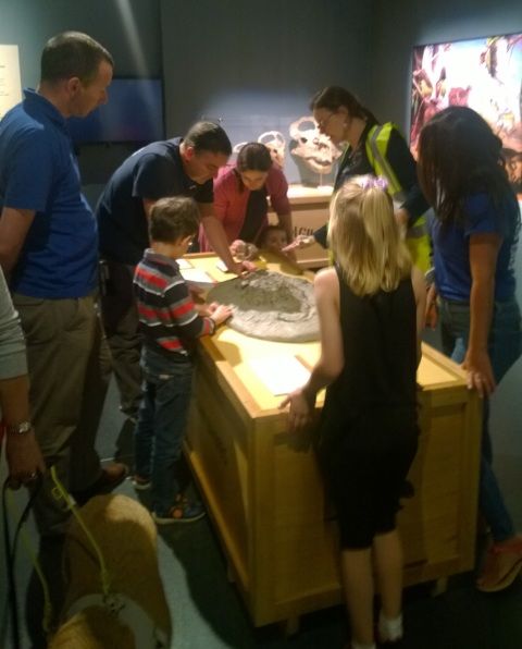 Photograph showing a museum staff member leading a sensory tour of the dinosaur babies exhibition.