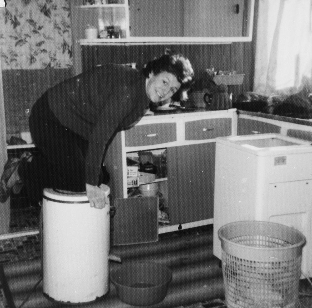 Mrs.Evelyn Potter, Taffs Well  coping with the electric spin drier by kneeling on top of it in the 1970s.