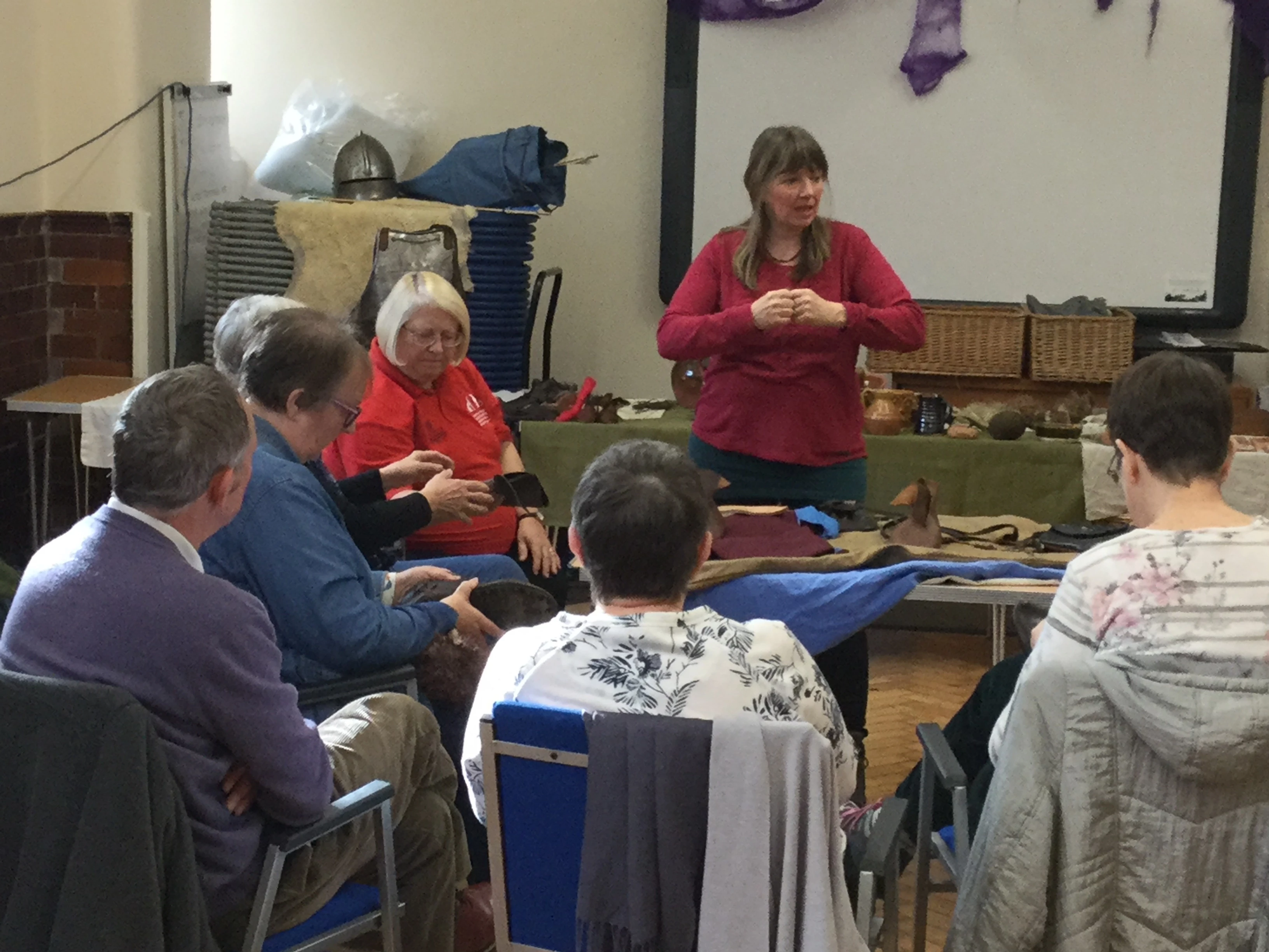 A group of people discussing some replica 15th century clothing