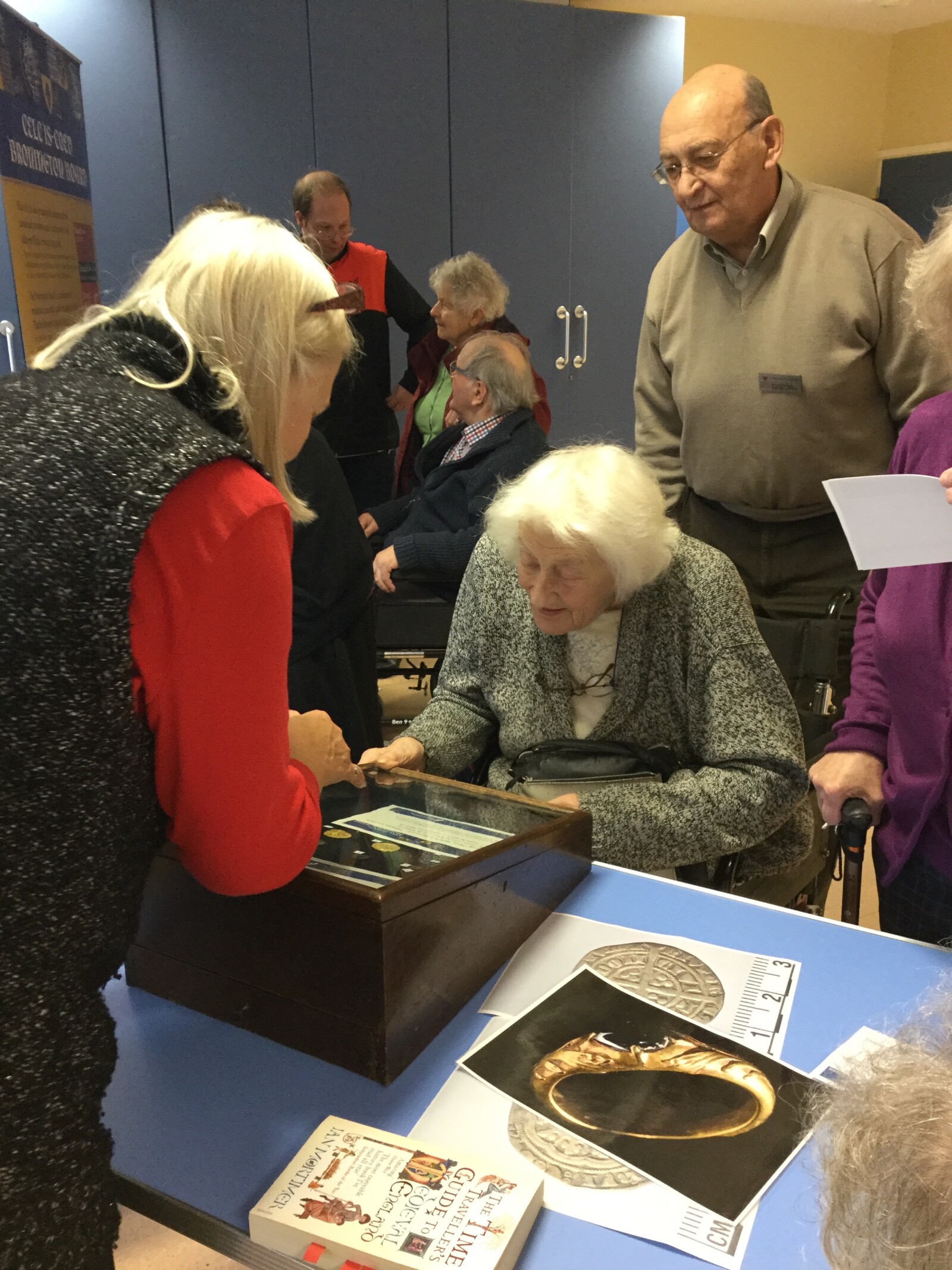 People discussing a display of coins.