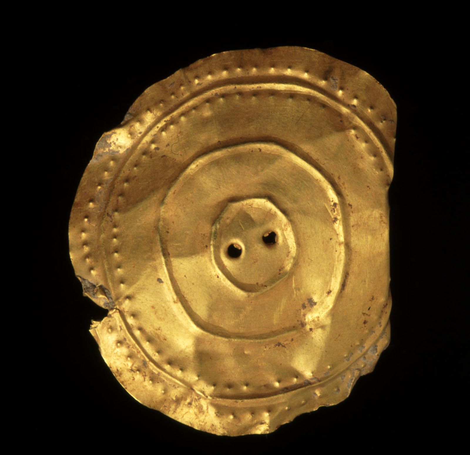 photograph of gold disc with repousse design