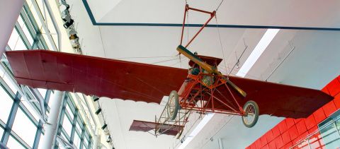 photograph of a small, early twentieth century airplane with red wings