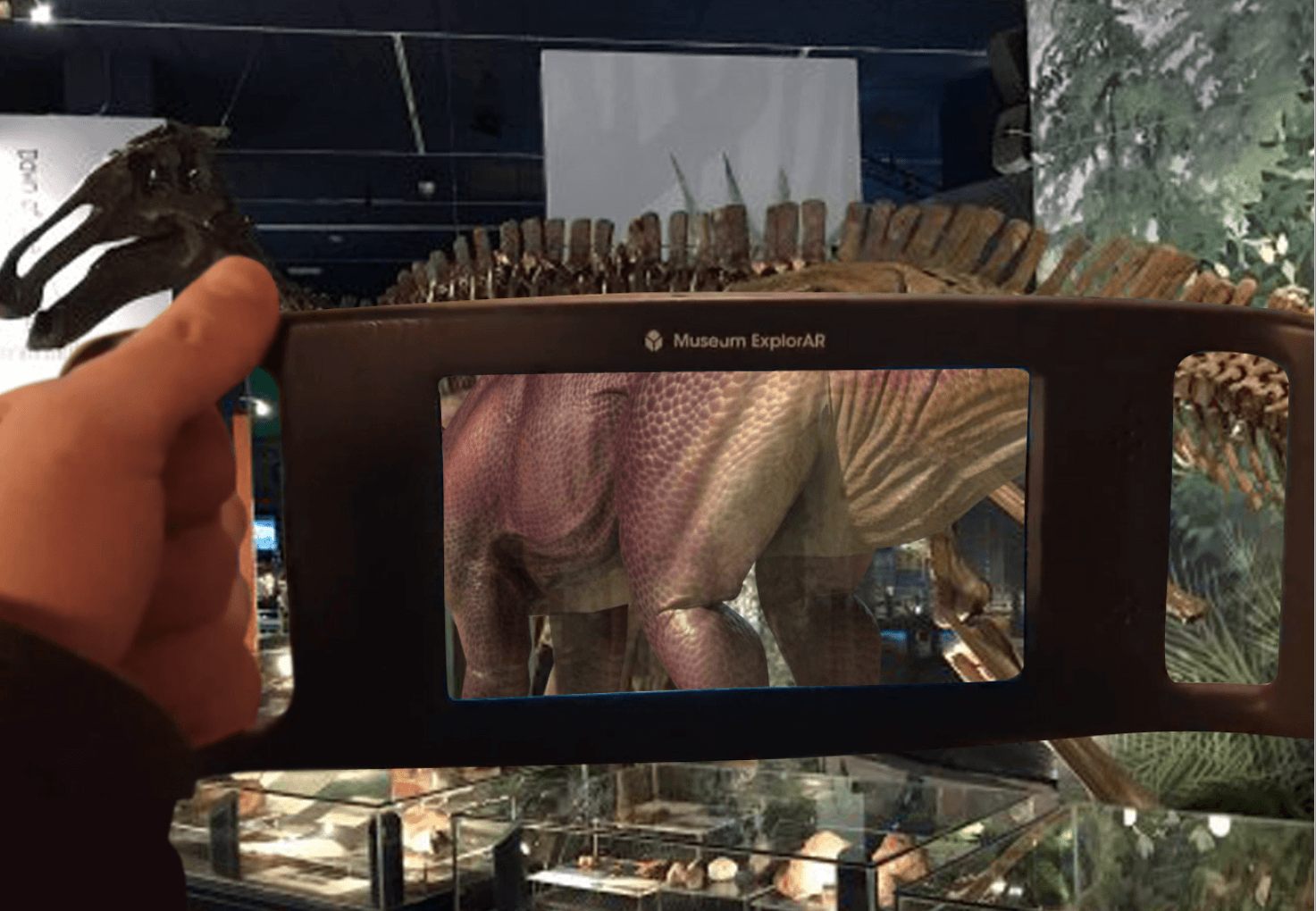 a device held up to a dinosaur skeleton showing augmented reality of the dinosaurs skin.