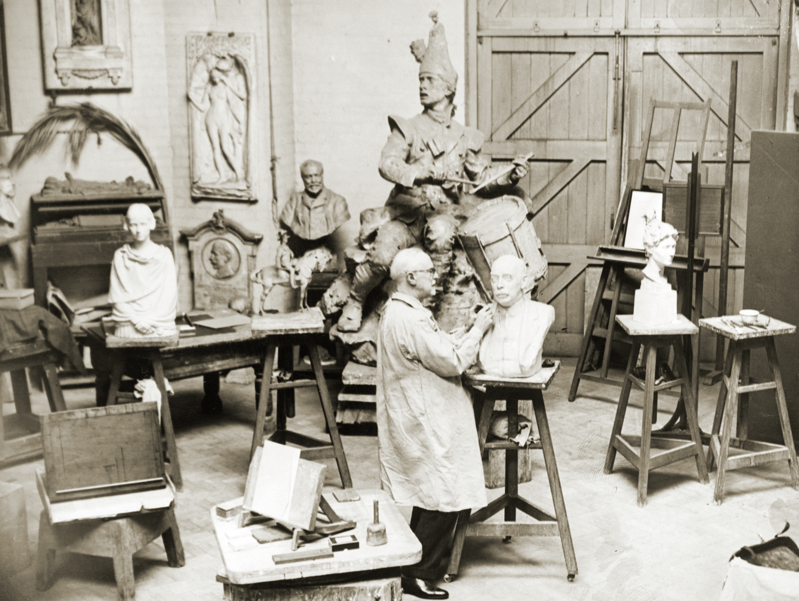 Photograph of William Goscombe John in the downstairs studio working on a marble bust.
