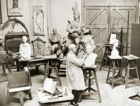 Photograph of William Goscombe John in the downstairs studio working on a marble bust.