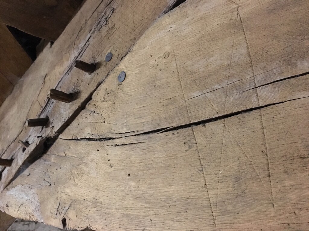 Image of large 'X' scratched into the roof truss of the 16th century Y Garreg Fawr farmhouse.