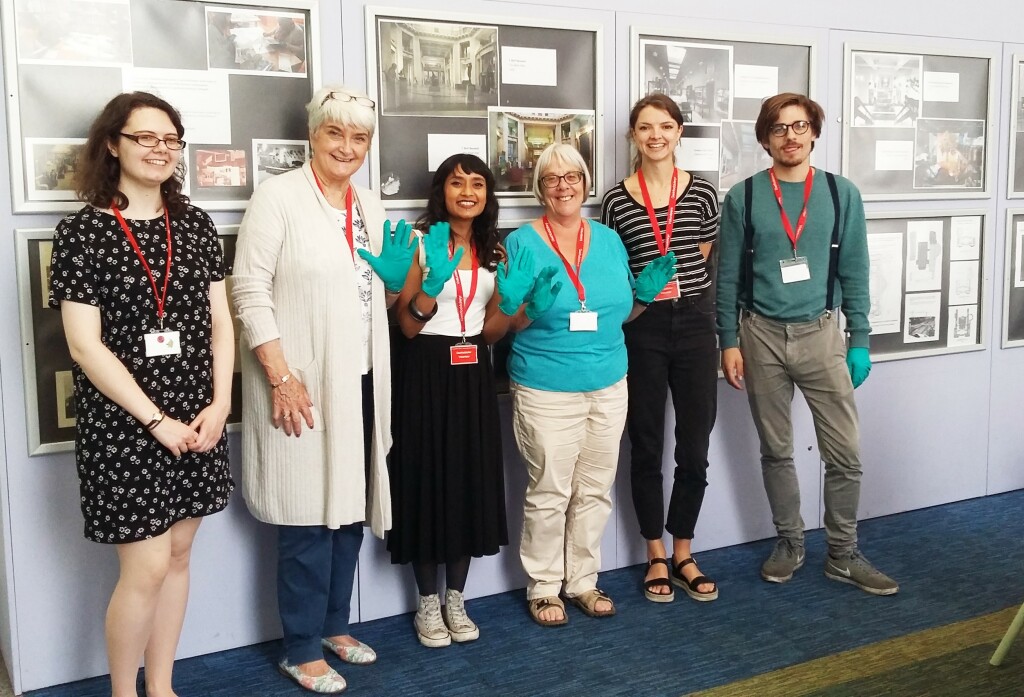 A group of volunteers standing against a wall.