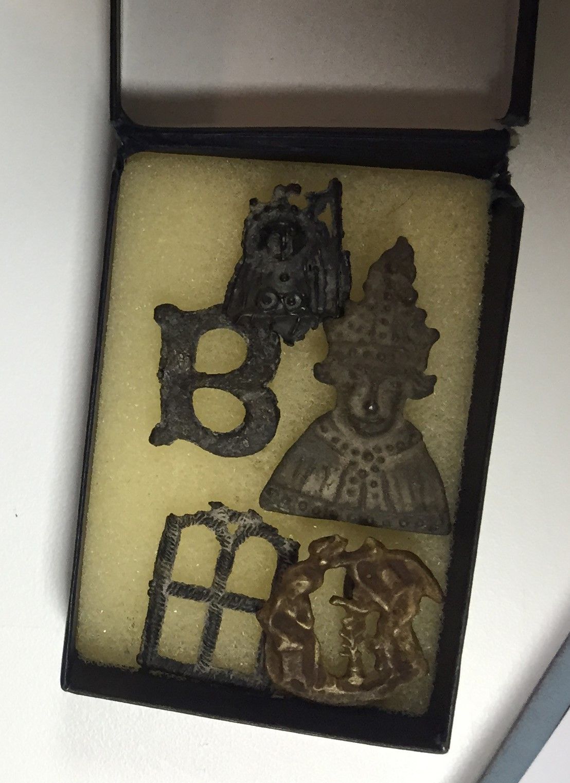 A small box containing five pilgrim badges