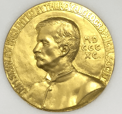 photograph of a gold medal with the portrait of man's head in profile