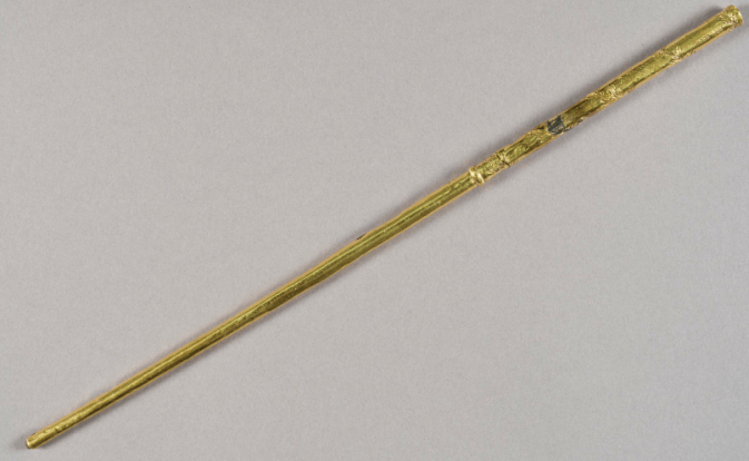 photograph of a gold conductor’s baton