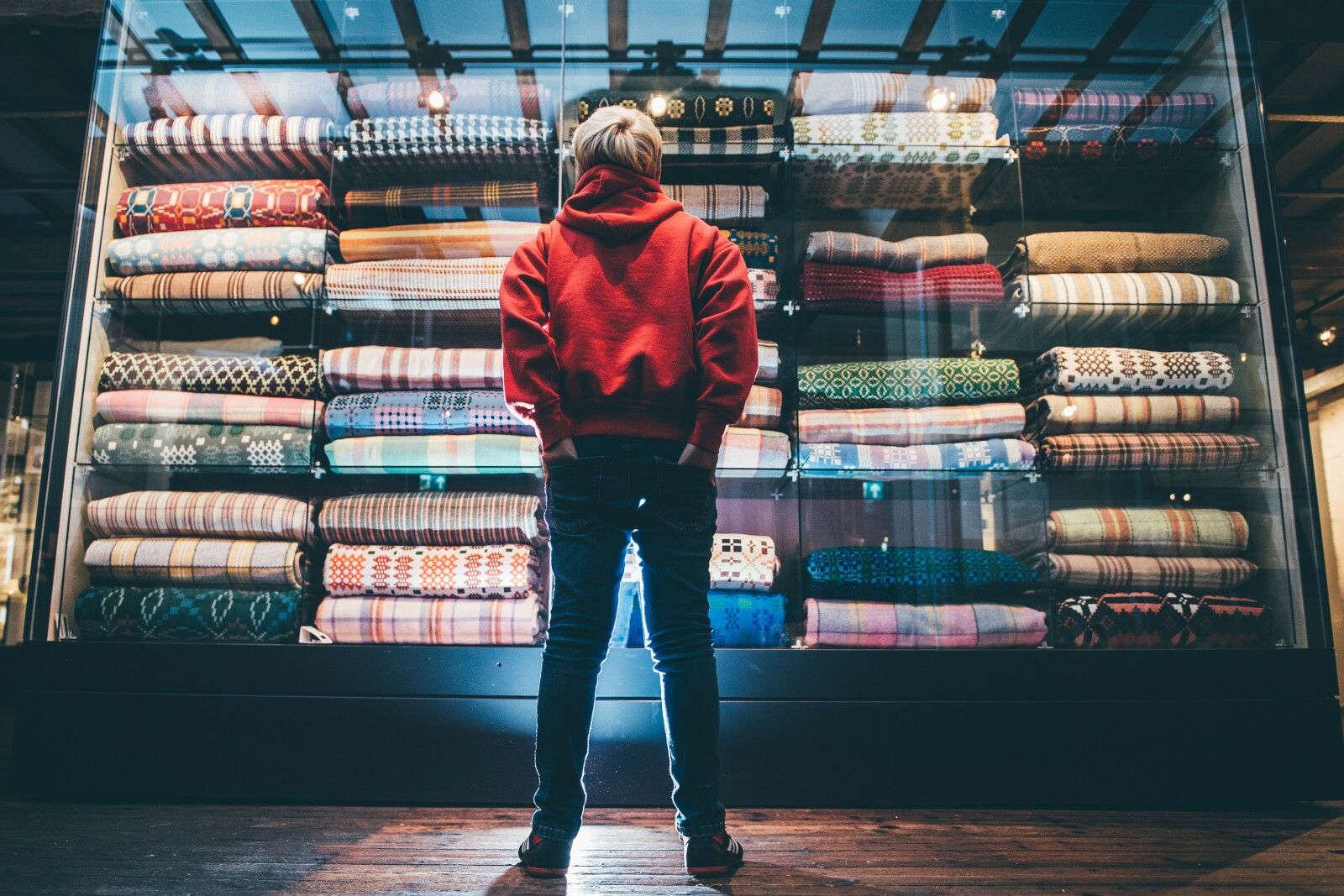 Boy standing in front of blankets at the Wool Museum