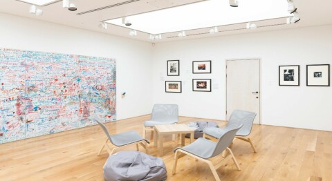 A photograph of the ARTIST ROOMS: August Sander exhibition, showing the visitor feedback section, with a graffiti comment wall, table and chairs and a bean bag