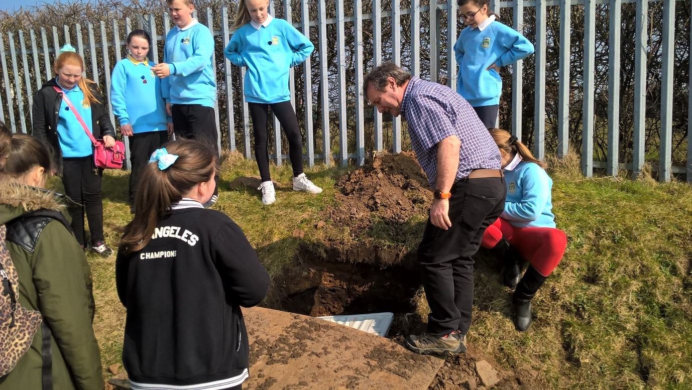 Burying a time capsule at the Penlan Community Centre garden
