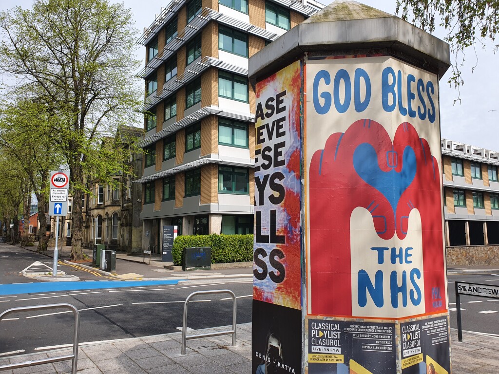 Cardiff street with a GOD BLESS THE NHS poster 