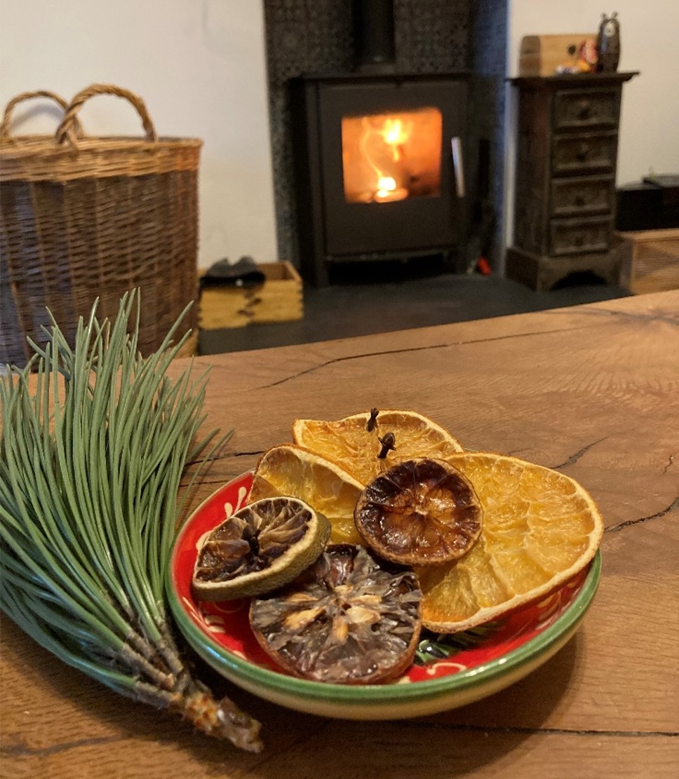 Photograph of sensory Christmas decorations in a bowl next to a log fire