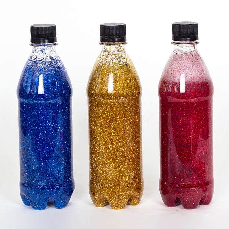 Photo of three bottles filled with blue, yellow and red glitter