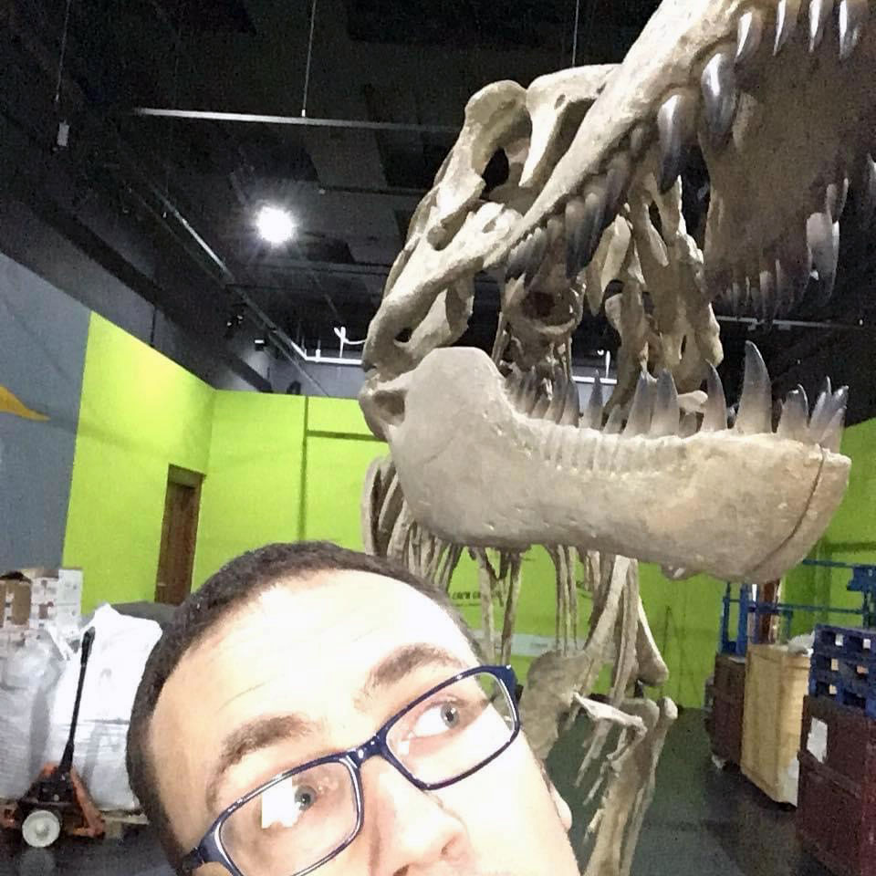 Man standing in front of a dinosaur skeleton.