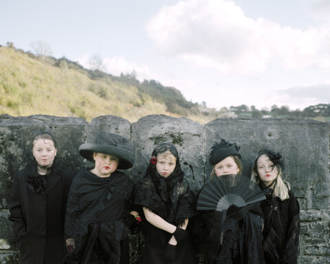 A group of young girls wearing black stand by a reservoir in Merthyr Tydfil