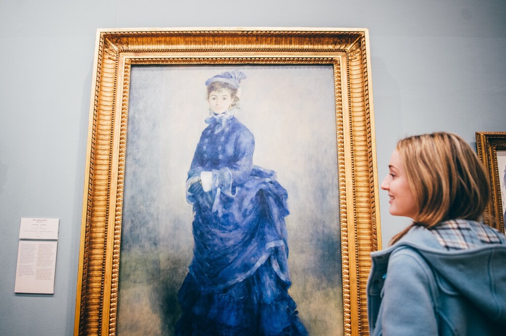 A young woman admires a painting by Renoir - La Parisienne
