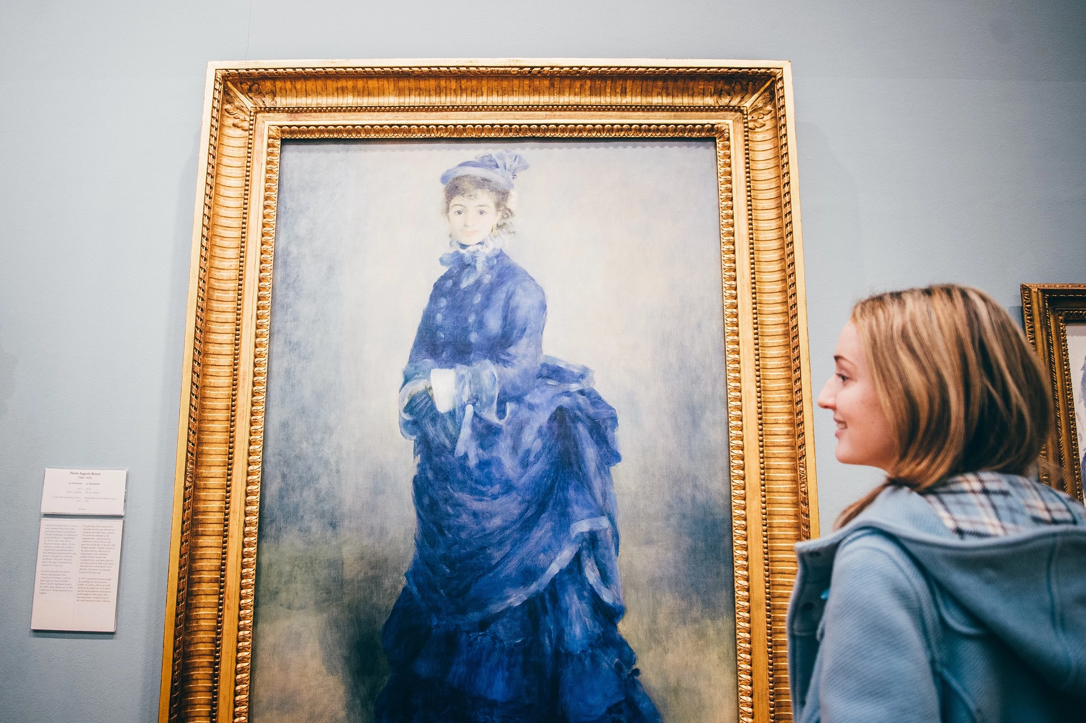 A young woman admires a painting by Renoir - La Parisienne