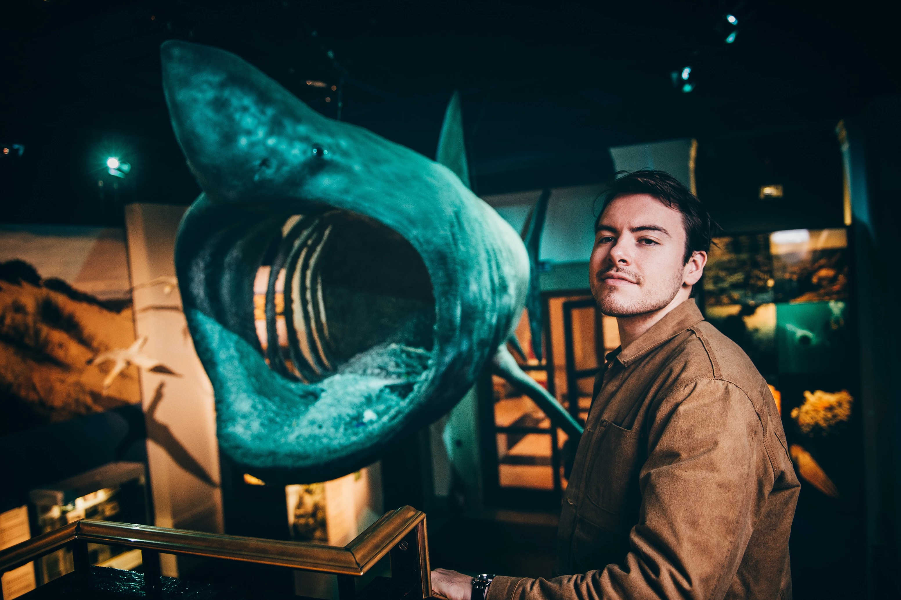 A man stands in front of a huge basking shark