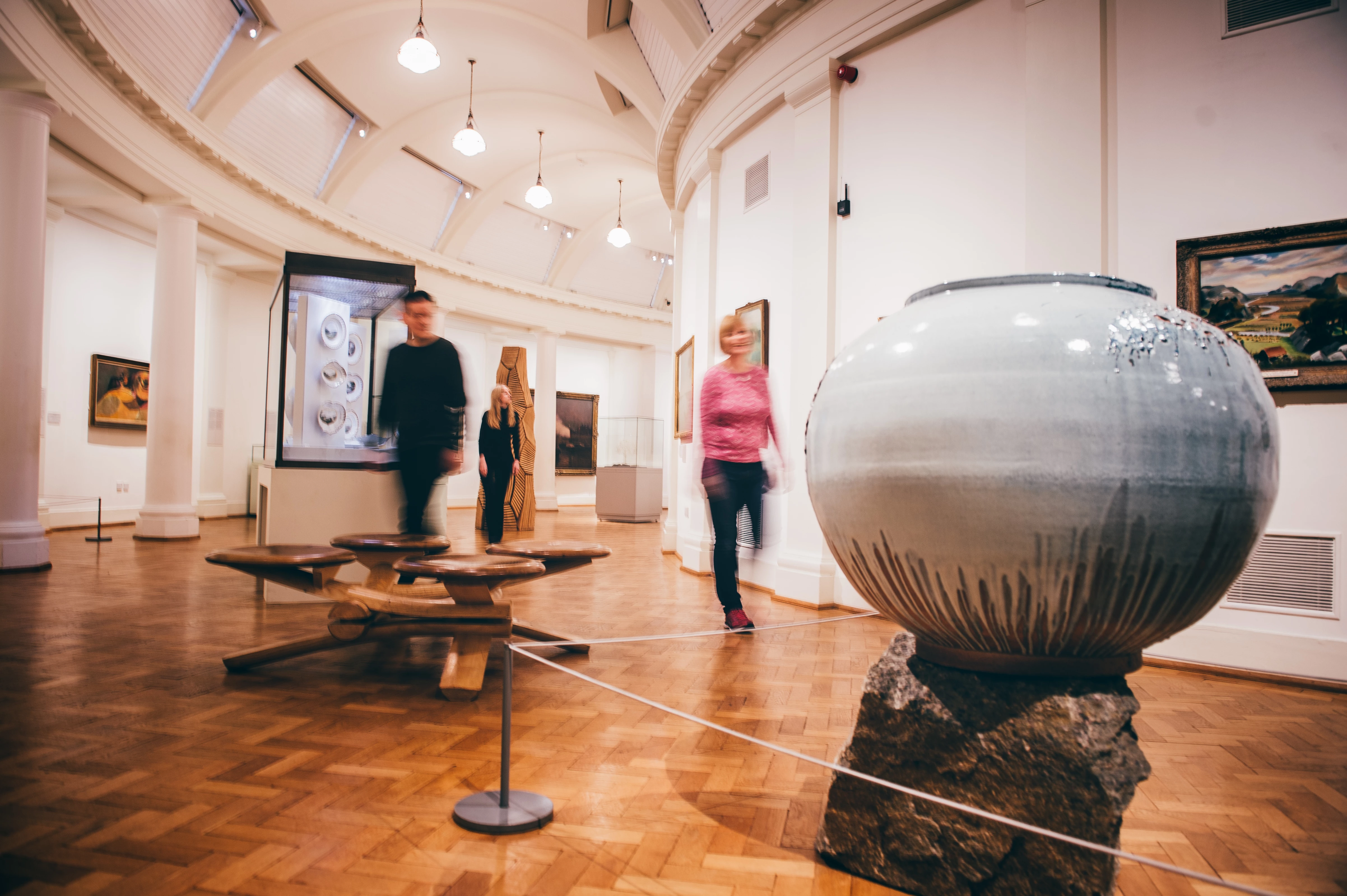 Three people walking through the Landscapes of Wales gallery