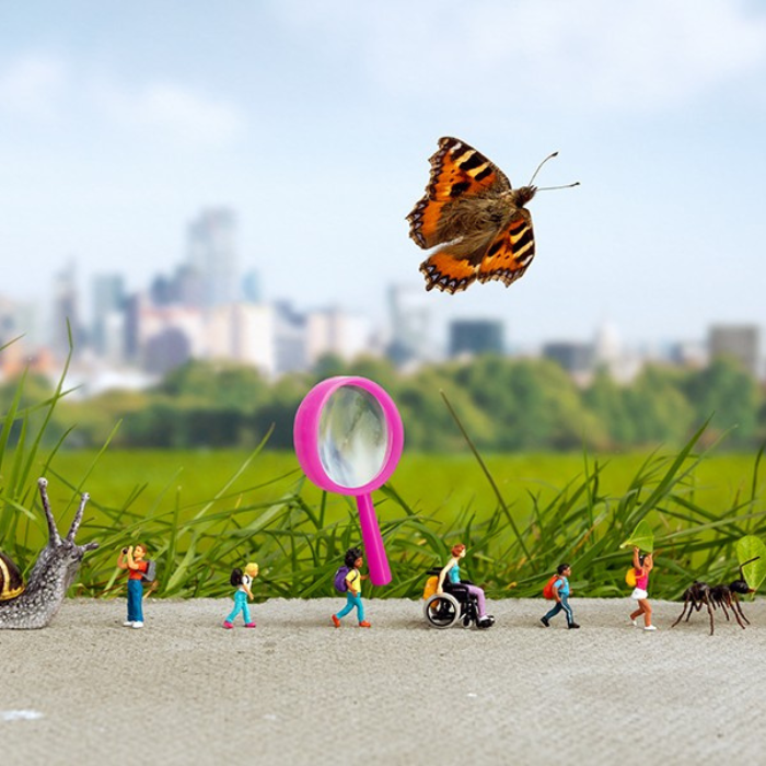 Photo of toy children walking in a line alongside a butterfly and a blue tit